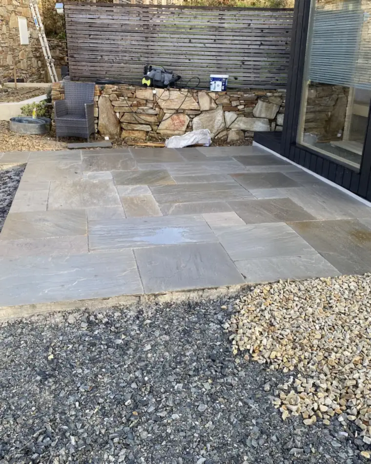 Sandstone-style patio slabs beside gravel